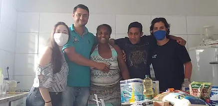 Equipo de Se Mudando reunido con la familia acompañada en la cocina de la casa.